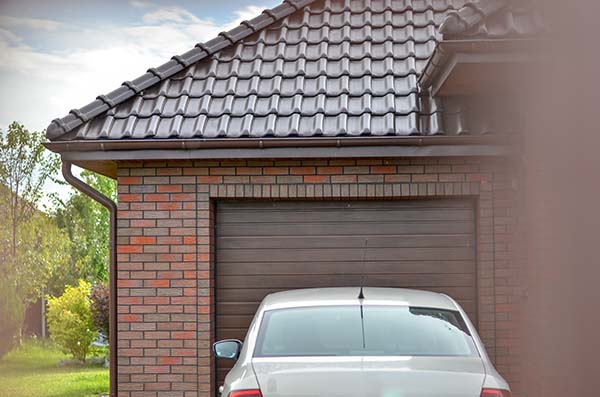 Grand River Garage Door service incorporates replacement, repair, and opener issues. A single stall garage attached to a brick house, the style of many Central Michigan homes.