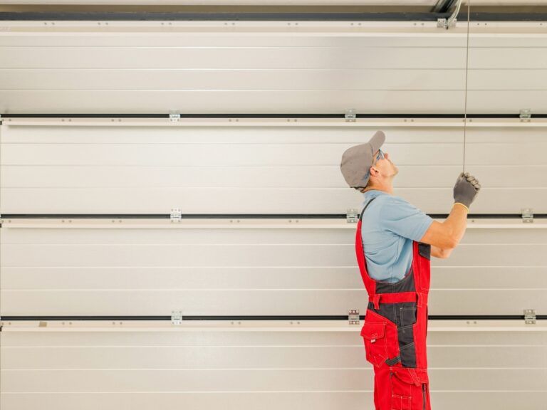 A new home garage door installation in Michigan. A technician works on garage door tracks.