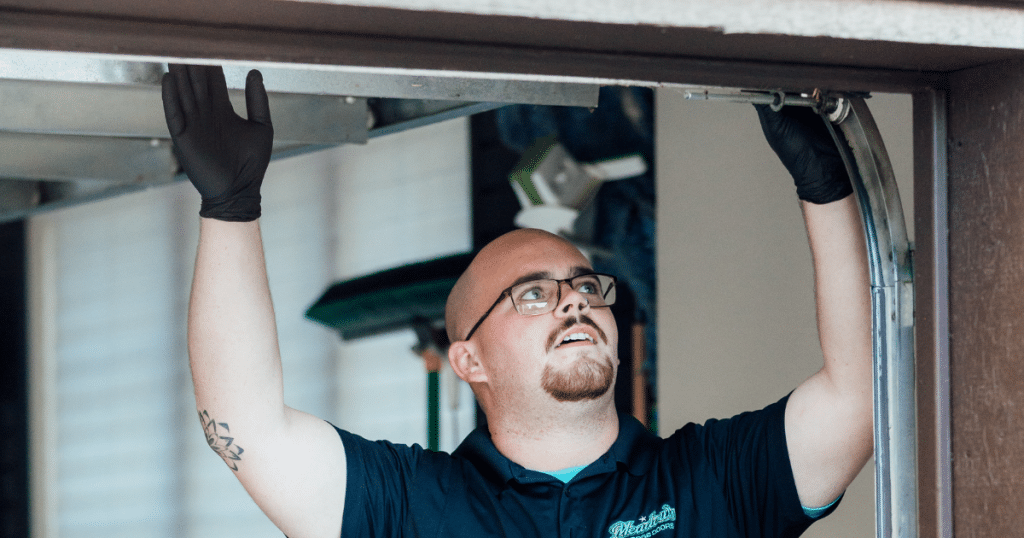 Technician aligns garage door track ends.